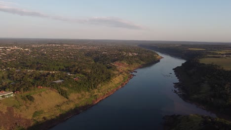 Luftaufnahme-Der-Flussverbindung-Zwischen-Brasilien,-Paraguay-Und-Argentinien-Bei-Sonnenuntergang