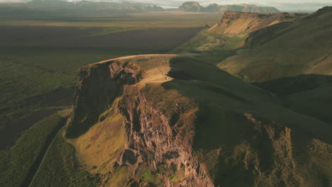 Aerial-flyover-above-dramatic,-rugged-cliffs-in-Iceland-at-golden-hour