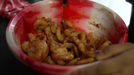 Close-up-shot-of-hands-mixing-frozen-prawns-using-spices-and-oil
