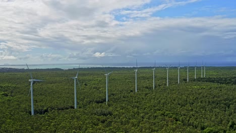 Drone-view---row-of-wind-turbines-in-middle-of-forested-landscape,-Mauritius
