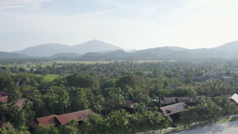 Close-up-to-total-view-tracking-shot-coastline-Langkawi,-beautiful-sunny-day,-beach,-trees-and-hills-in-the-background,-no-people,-daylight