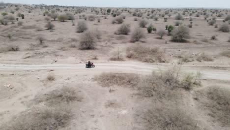Aerial-View-Of-a-biker-Riding-Bike-Through-Desert