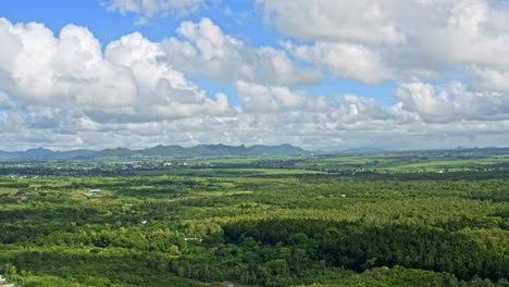 Beautiful-blue-sky-with-puffy-white-clouds-over-lush-green-landscape,-Mauritius