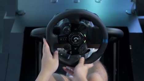 A-Chinese-gamer-plays-and-uses-a-car-wheel-from-a-themed-racing-videogame-as-visitors-attend-the-Hong-Kong-Computer-and-Communications-Festival-in-Hong-Kong