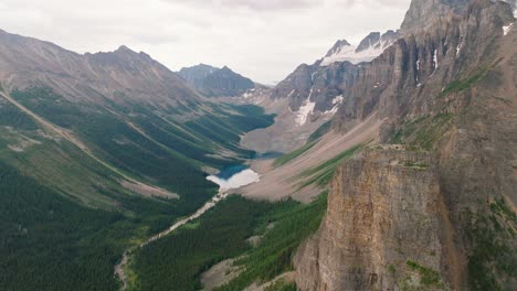 órbita-Aérea-Sobre-La-Cordillera-De-Las-Montañas-Rocosas-Canadienses,-El-Bosque-De-Pinos-Verdes-Y-El-Lago-En-El-Parque-Nacional-De-Banff,-Alberta,-Canadá
