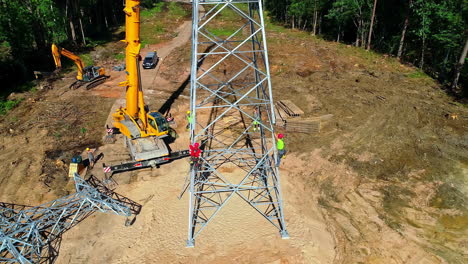 Workers-working-on-electrical-tower-for-electricity-supply-in-rural-area