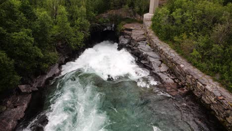 Wild-powerful-river-flowing-under-the-bridge,-tilt-up
