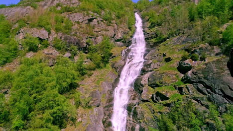 Tiefwinkelaufnahme-Eines-Wunderschönen-Wasserfalls-In-Felsigen-Bergen-In-Aurland,-Norwegen-An-Einem-Schönen-Sonnigen-Tag-Mit-Blauem-Himmel-Im-Hintergrund
