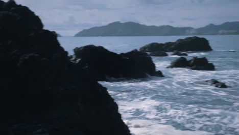 Wellen,-Die-Gegen-Die-Großen-Schwarzen-Felsen-An-Der-Küste-Schlagen