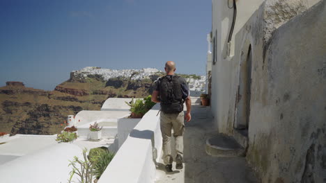 Folgen-Sie-Einem-Mann,-Der-An-Einem-Sonnigen-Tag-Auf-Der-Insel-Santorini-Spazieren-Geht