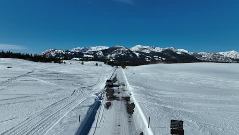 Car-Parked-On-Snowy-Track-With-Puddle-In-Stanley,-Idaho