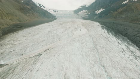 Aerial-dolly-in-over-white-Columbia-Icefield-Glacier-between-Canadian-Rockies-at-Banff-National-Park,-Alberta,-Canada