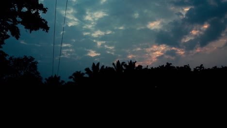 Blauer-Bewölkter-Himmel-Am-Abend-Mit-Silhouetten-Tropischer-Bäume-Vorne,-Himmelshintergrund