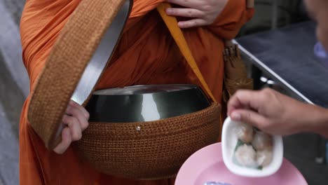 Traditional-Temple-Warship-Tradition-Culture-Religion,-Buddhist-Monk-receives-Offerings-via-Monk-Bowl