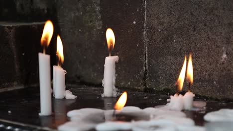 Close-view-of-lots-of-burning-candles-on-the-floor
