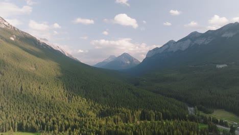 órbita-Aérea-Sobre-La-Cordillera-De-Las-Montañas-Rocosas-Canadienses-Cubierta-Por-Un-Denso-Bosque-De-Pinos-En-El-Parque-Nacional-De-Banff,-Alberta,-Canadá