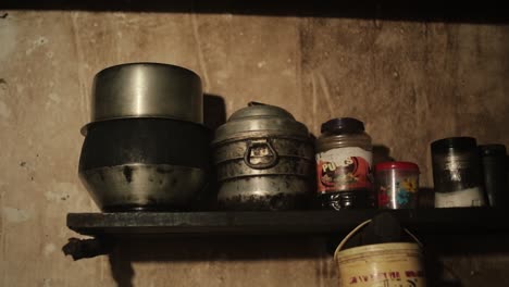 Zoom-in-shot-of-metal-pans-and-pots-with-spices-in-typical-Indian-farmhouse