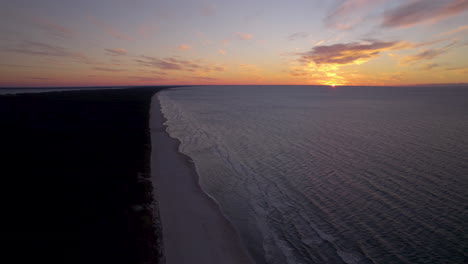 Dramatic-Colorful-Sunset-over-Baltic-Sea-Horizon-Level-from-Krynica-Morska-spit-in-Poland-aerial-view