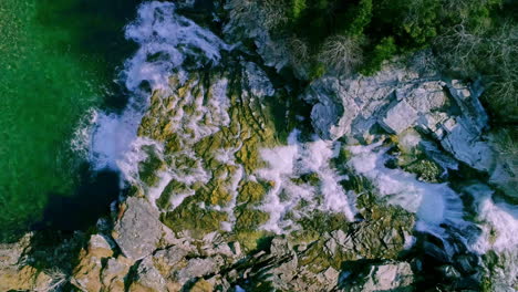 Aerial-drone-bird's-eye-view-over-a-water-from-waterfall-and-rapids-falling-into-river-in-Aurland,-Norway-at-daytime