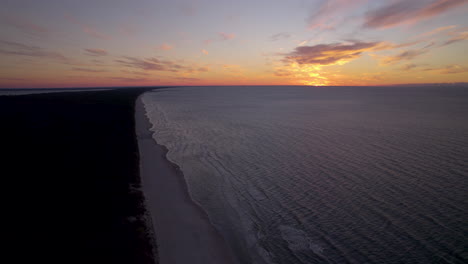 Aerial-view-of-Krynica-Morska-Coastline-at-Sunset,-Sun-Hid-Over-Baltic-Sea-on-a-Cloudy-Summer-Day-in-Poland---aerial