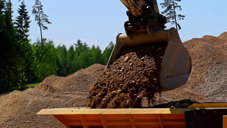Slow-motion-shot-of-excavator-shovel-arm-pick-rocks-and-unloading-in-container