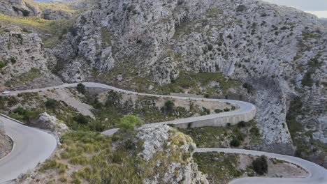 Revealing-shot-of-hairpin-bends-on-a-mountain-road-at-Sa-Calobra,-Mallorca,-Spain