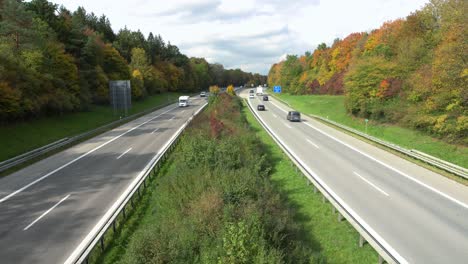 Fast-driving-cars-at-a-German-Autobahn-in-the-fall-season---dynamic-zoom-out