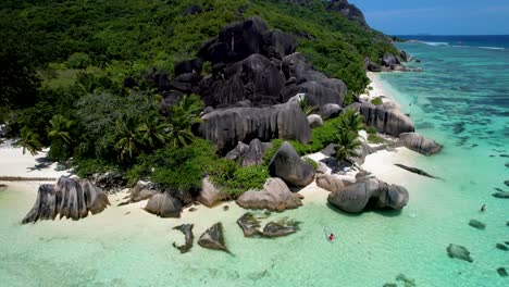 Aerial-view-of-Anse-Source-D'argent-Beach-in-the-Seychelles-Zoom-in-with-woman-in-clear-bottom-kayak