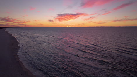 Colorful-Pink-Color-Sunset-Sky-With-Fluffy-Clouds-Over-Baltic-Sea-and-Coastline,-Poland---aerial