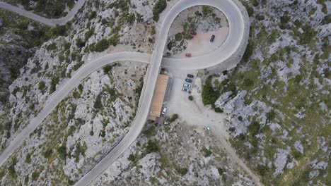 Straight-down-view-of-a-mountain-road-that-loops-underneath-itself-at-Sa-Calobra,-Mallorca,-Spain