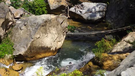 Man-jumps-from-a-large-rock-into-a-river-in-Oaxaca,-Mexico