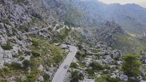Short-drone-clip-of-car-driving-down-a-windy-road-in-the-mountains-of-Sa-Calobra,-Mallorca,-Spain