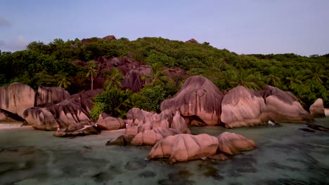 Aerial-zoom-in-of-Iconic-Seychelles-Beach-with-boulders-at-sunset