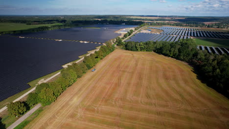Campo-Agrícola-Después-De-La-Cosecha-Y-Enormes-Paneles-De-Energía-Solar-Granja-Eléctrica-En-Polonia-Vista-Aérea