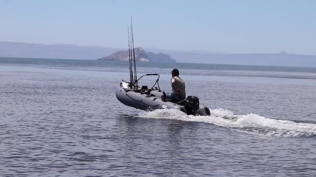 Premium stock video - Inflatable boat skipping accros the water