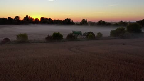 Tractor-sitting-in-field-being-harvested-at-sunset-during-harvest-season