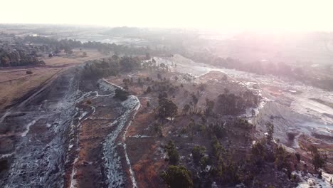 Aerial-drone-shot-tracking-backwards-over-an-old-abandoned-mine-dump-during-sunrise-on-a-beautiful-day,-Benoni,-South-Africa
