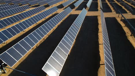 Solar-panel-farm-aerial-side-view-in-Mojave-desert,-eco-environmental-concept