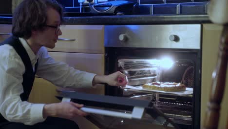 A-young-man-has-his-pizza-in-the-oven-and-prepares-for-a-meal