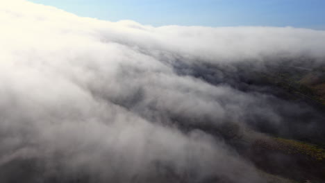 Looking-from-above-the-low-lying-fog-in-Brisbane,-California---aerial-view-of-a-misty-morning