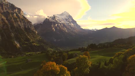 aerial-drone-footage-dolly-right-to-left-over-sycamore-maple-trees-with-stunning-view-of-Eiger-North-Face-and-lenticularis-clouds