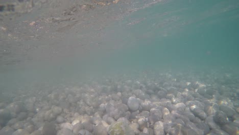 Action-cam-inside-shorehline-shallow-water-where-small-waves-crash