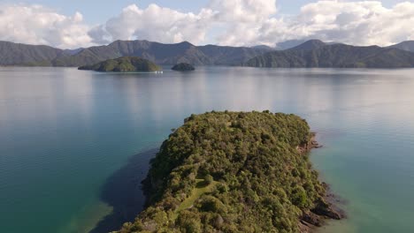 Overgrown-peninsula-reaching-out-onto-the-turquoise-ocean-within-Marlborough-Sounds,-New-Zealand