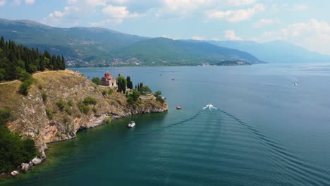 Aerial-view-of-a-boat-on-Lake-Ohrid-North-Macedonia-passing-traditional-orthodox-church