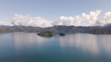 Diminutas-Islas-Frente-A-Una-Majestuosa-Cordillera-Costera-Y-Las-Espesas-Nubes-Que-Se-Reflejan-En-El-Agua-Azul-Turquesa-Del-Océano