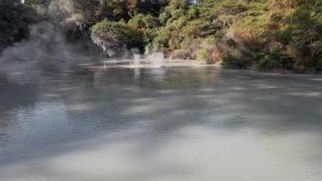 Low-aerial-fly-over-shot-of-the-steaming-hot-mud-pools-of-Waiotapu-in-Slow-motion