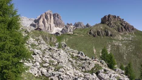 Aerial-tracking-shot-showing-group-of-hiker-on-Rifugio-Roda-di-Vael-Hiking-Path-during-sunny-day-in-Dolomites
