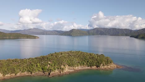 Flying-above-an-overgrown-peninsula-in-the-Marlborough-sounds-and-towards-coastal-mountains
