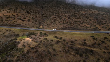 Drohnenvideo-Eines-Autos,-Das-Die-Bergstraße-Durch-Wolken-Auf-Dem-Haleakala-Vulkan-In-Maui,-Hawaii,-Hinauffährt