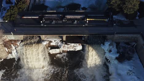 Drone-video-looking-down-at-Rideau-Falls-in-Ottawa-Ontario-Canada-during-spring-while-ice-is-beginning-to-break-up